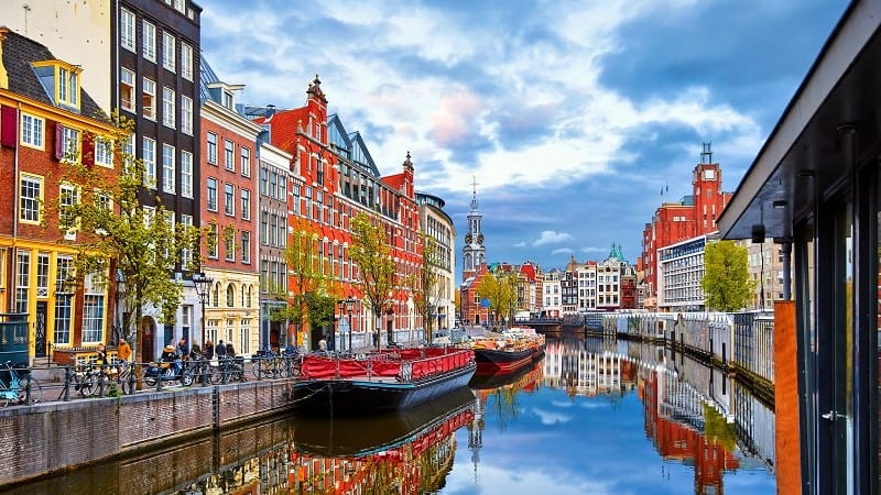 Channel in Amsterdam Netherlands houses river Amstel landmark old european city spring landscape.