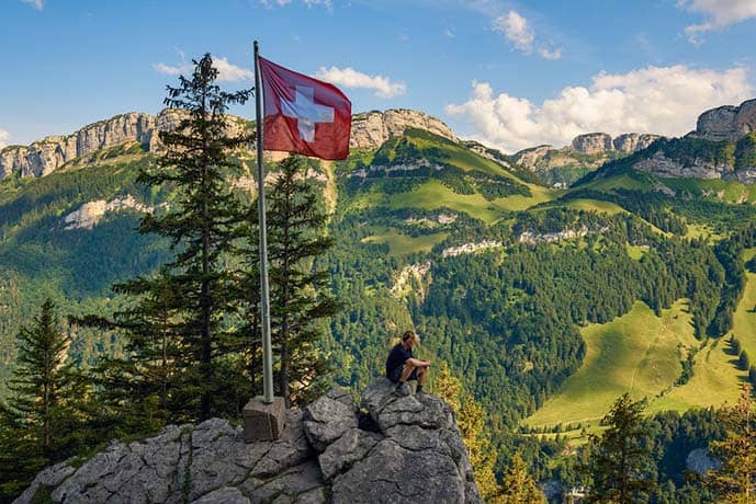 Tourist sitting on the Ebenalp mountain in the Swiss Alps of Switzerland