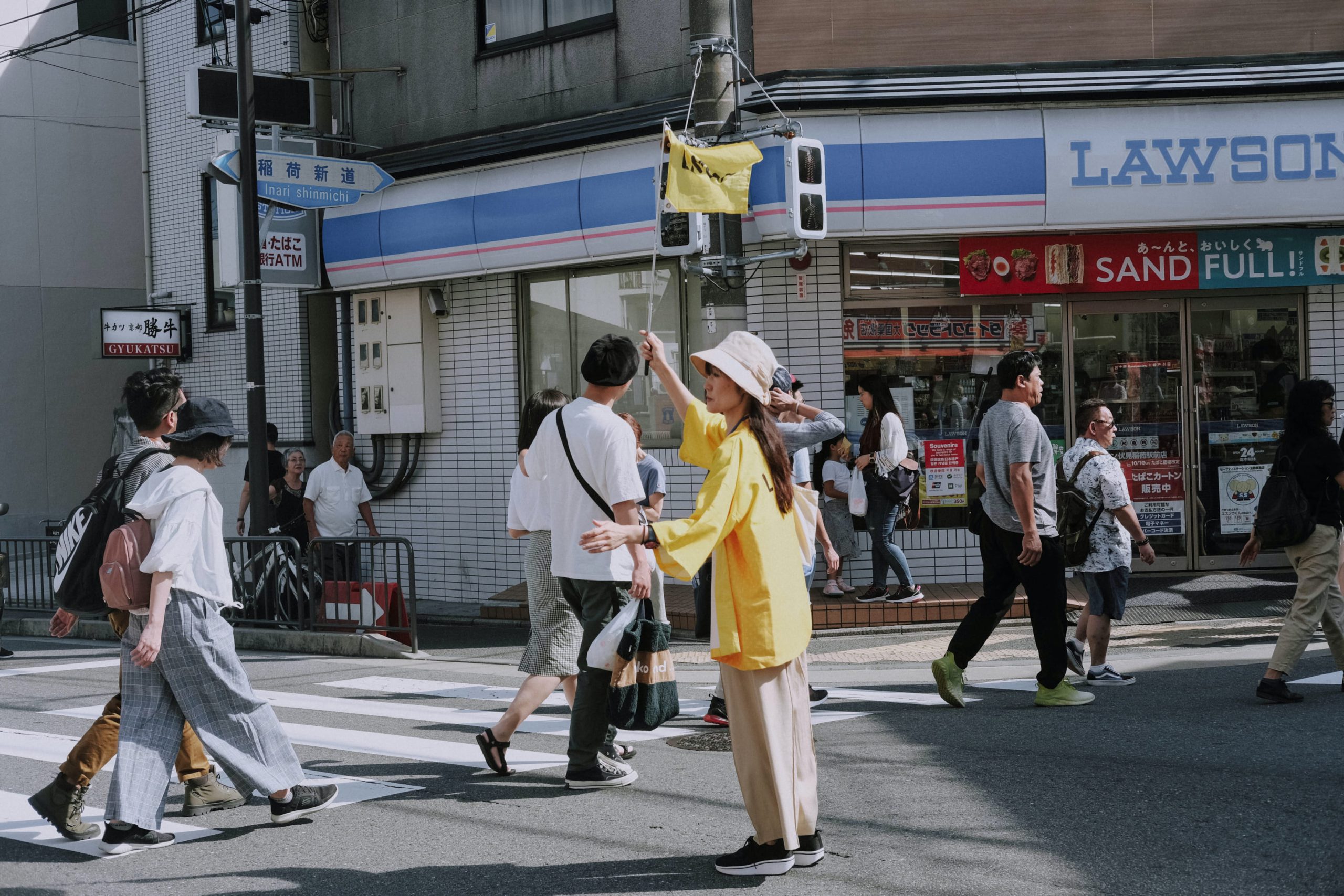 Pedestrain crossing the street outside a convenience store in Japan.