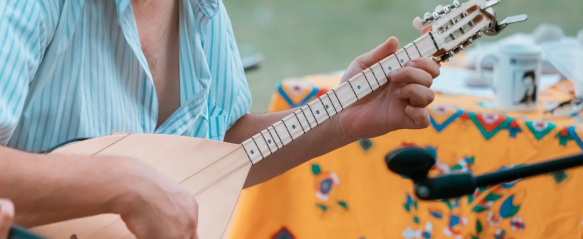 Musician playing a traditional string instrument in a Xinjiang village.