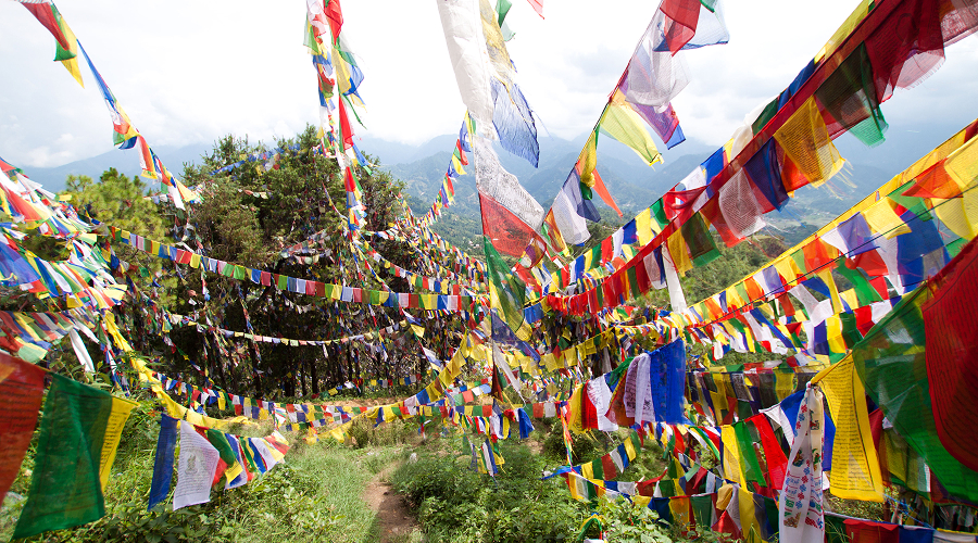 色彩斑斓的藏传祈祷旗在风景如画的山隘间迎风飘扬。